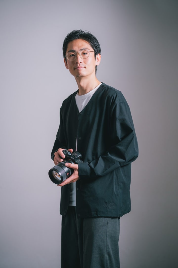 カメラを手にしたフォトグラファー KOTARO MANABE のポートレート